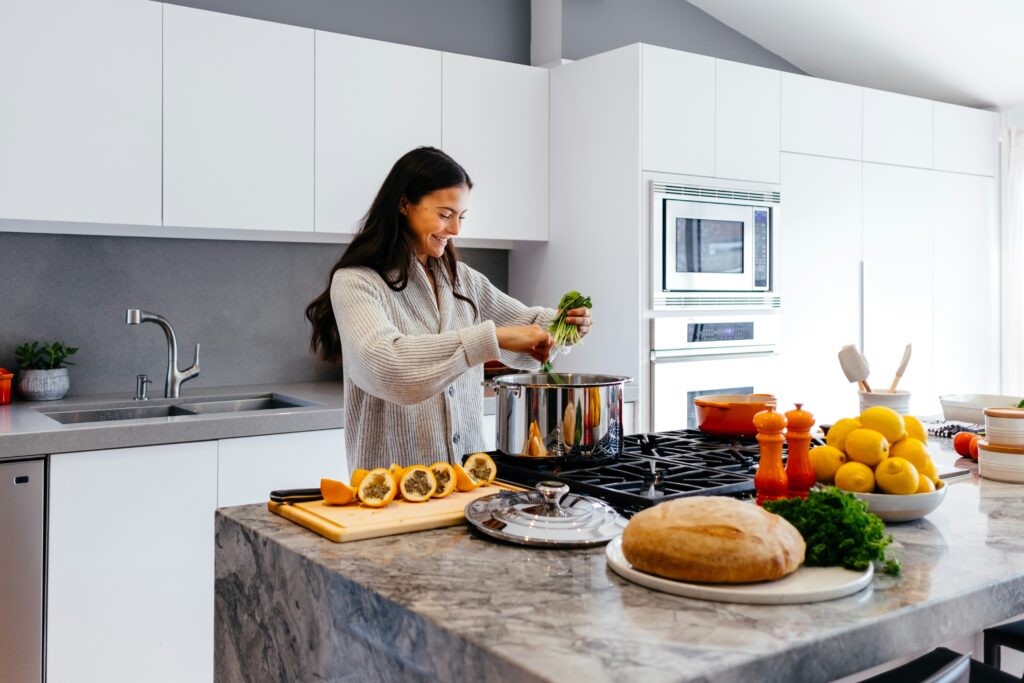 A woman preparing food in a bright, clean kitchen.