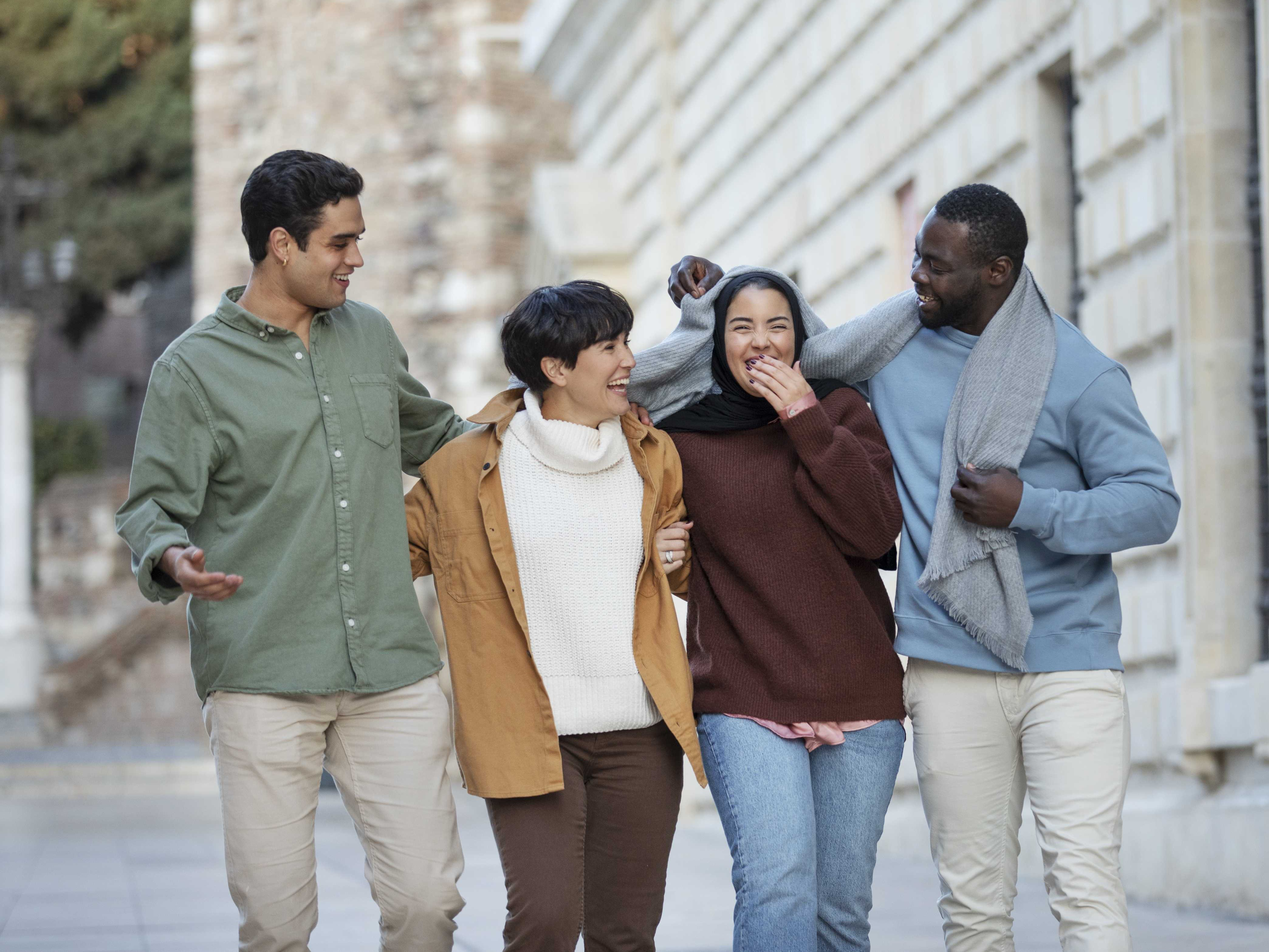 A group of men and women laughing and smiling together.