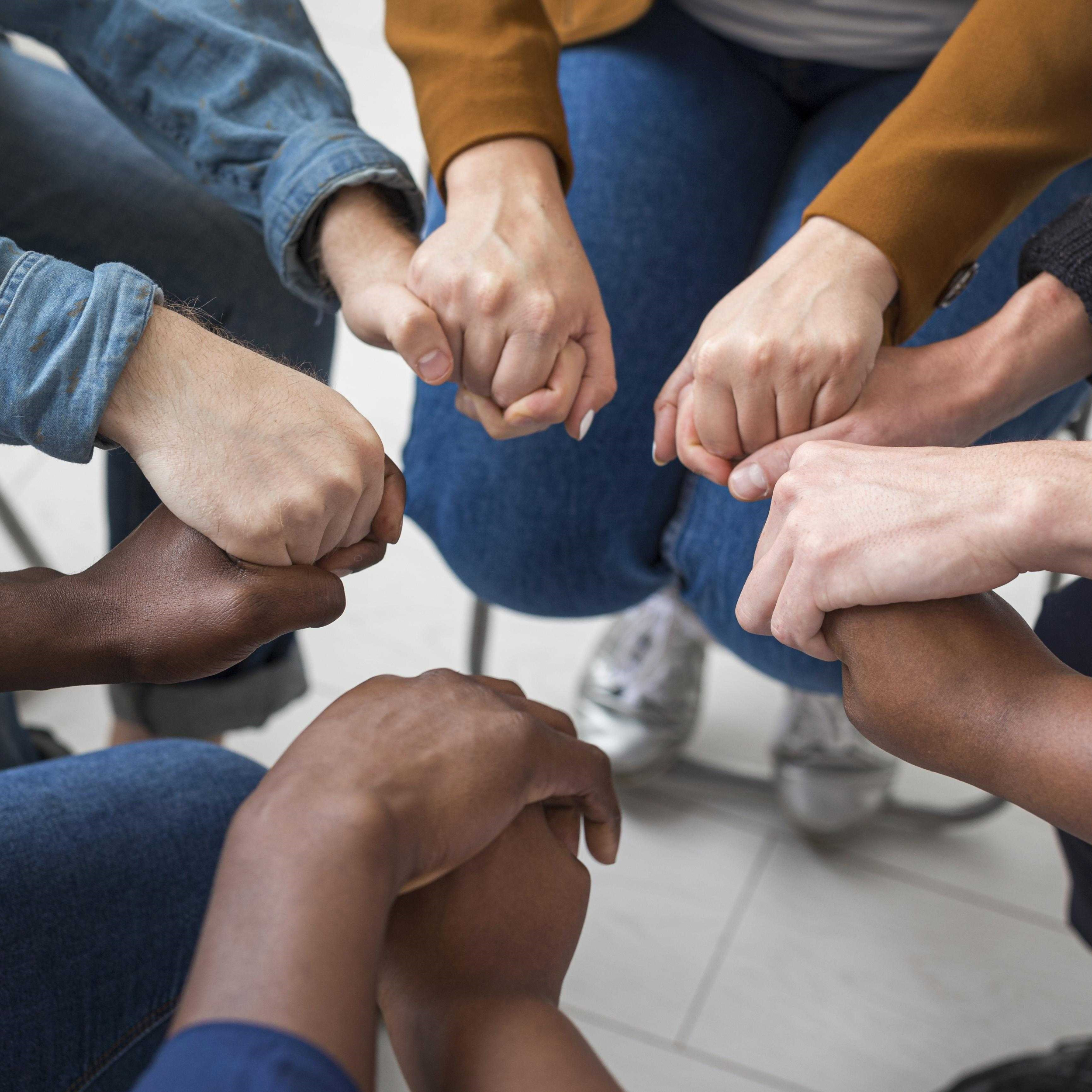 A support group sat in a circle, holding hands.