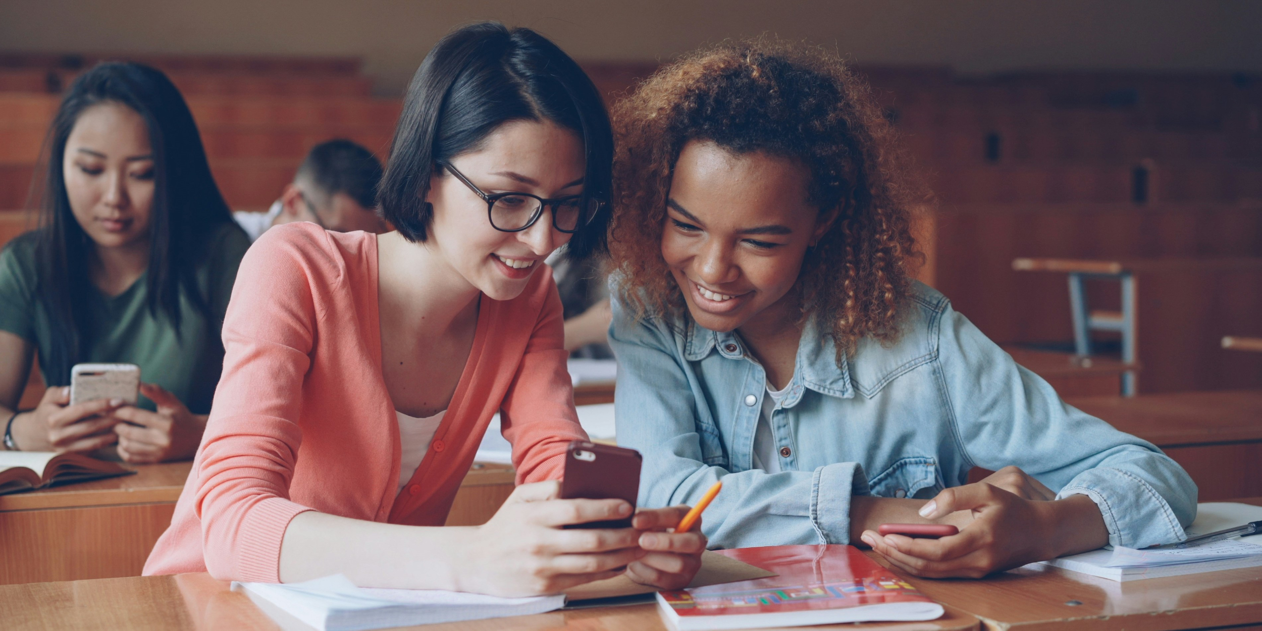 A group of young people sharing stories on their phones.