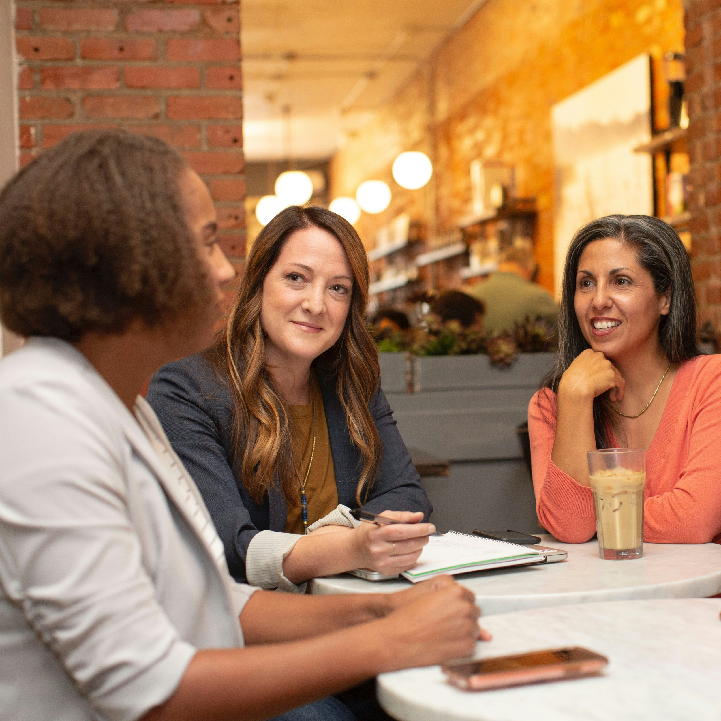 A group of women having an informal meeting in a cafe.