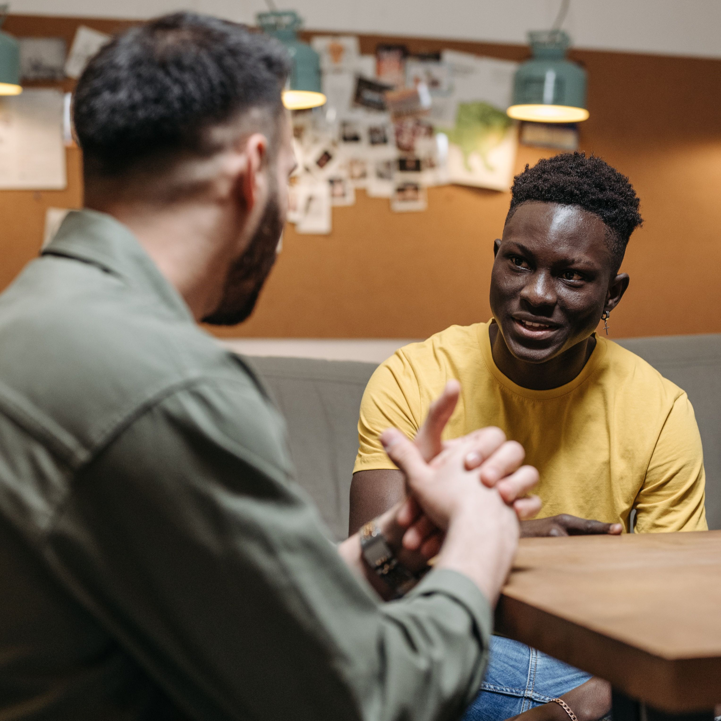 Two men seated at a table, talking.