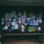 A bus shelter with lots of flyers posted against the back.