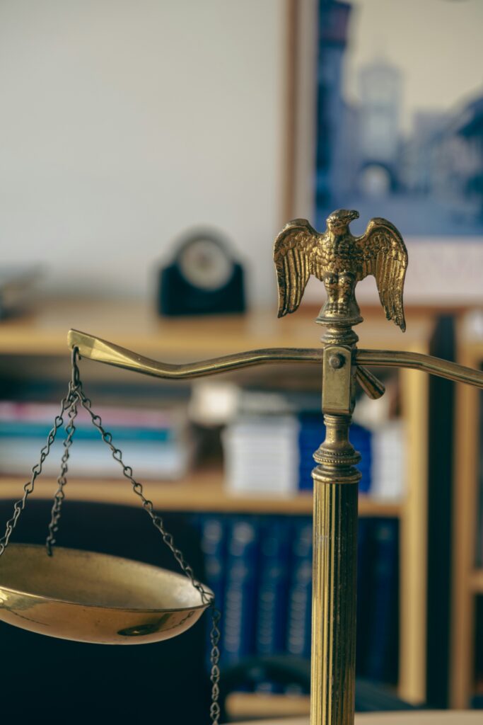 A set of brass scales with an eagle figure at the top, depicting legal justice.
