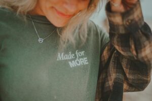 A woman wearing a sweatshirt with the message 'Made for MORE'.